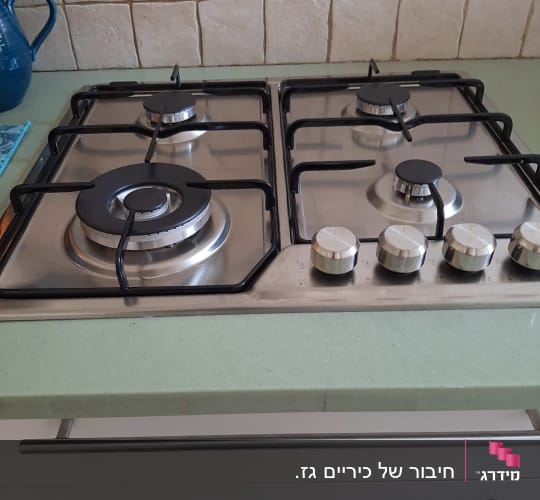 כיריים גז עם ארבעה מבערים וכפתורי שליטה